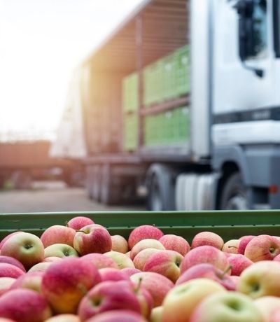 Apples in container ready for shipping near a truck