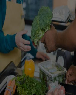 Customer handing a sales assistant broccoli