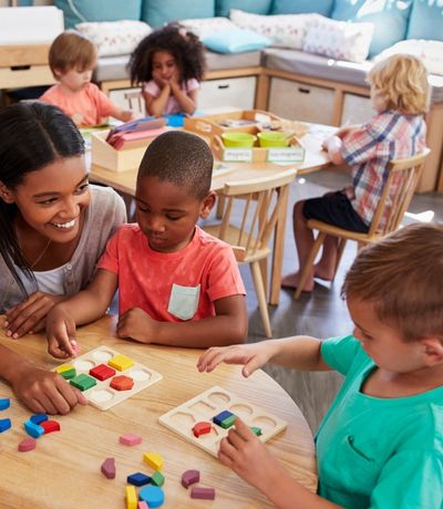 Teacher with preschool students at a desk