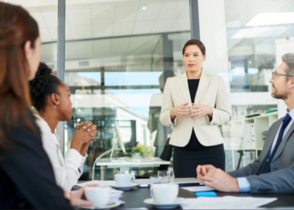 Colleagues discussing work around an office table 