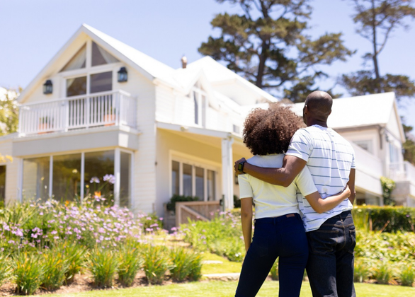 Couple in a garden looking at a house