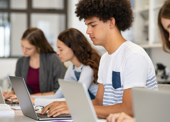 Students at desks working on laptops