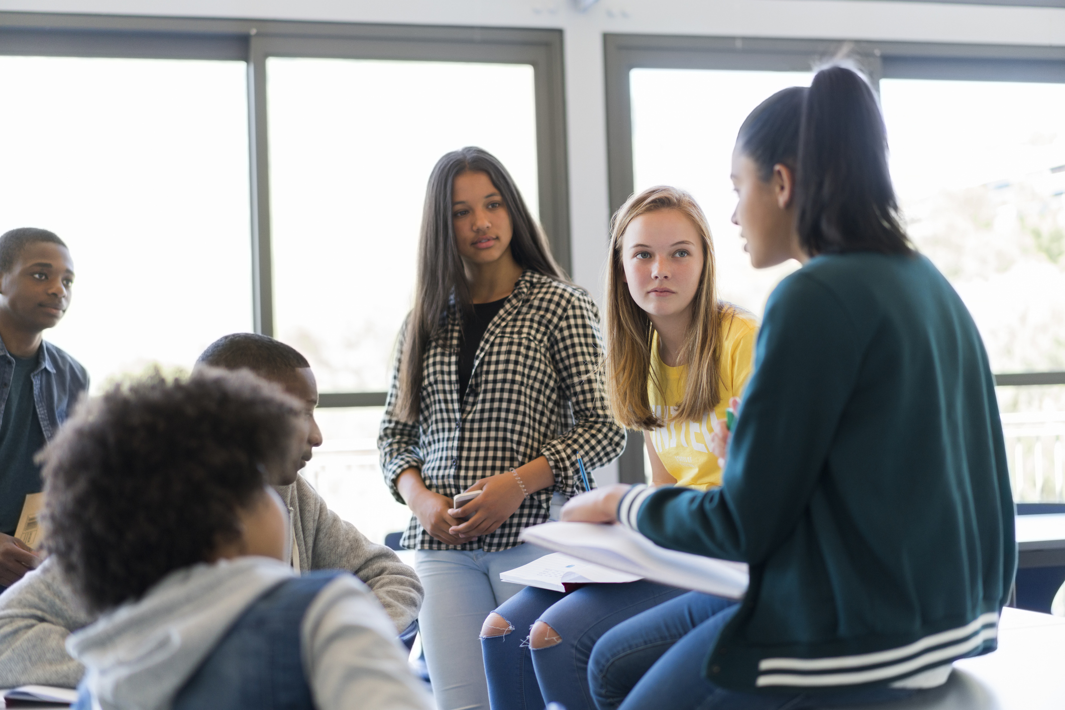 A group of youths having a discussion in a classroom