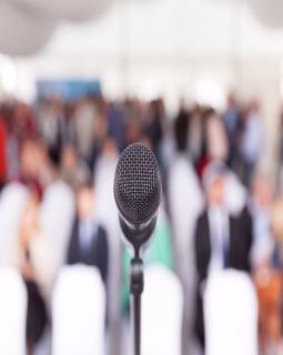 Microphone in focus against a blurred audience