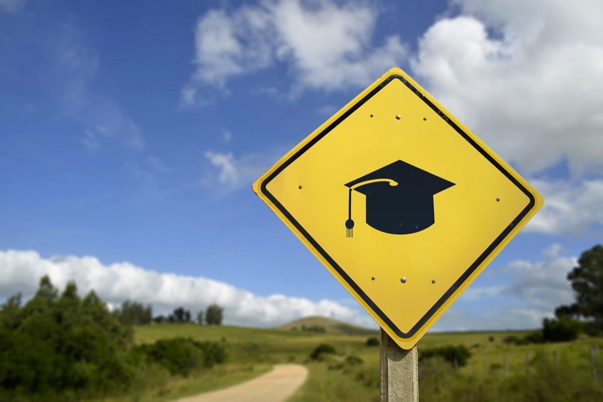 Graduation cap sign on a rural road