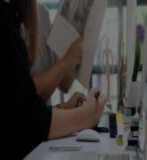 Two women review a magazine at a desk