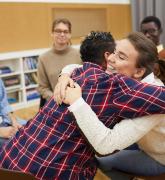 Two youth hugging in support group meeting