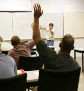 adult student in classroom with hand raised