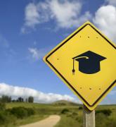 Graduation cap sign on a rural road