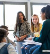 A group of youths having a discussion in a classroom
