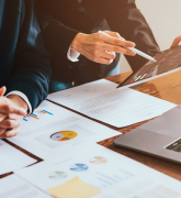 Trader looking on tablet and laptop with graphs analysis