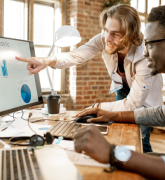 Two males working at a computer with graphs