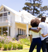 Couple in a garden looking at a house