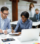 Two businesspeople reviewing business reports in the office.