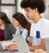 Students at desks working on laptops